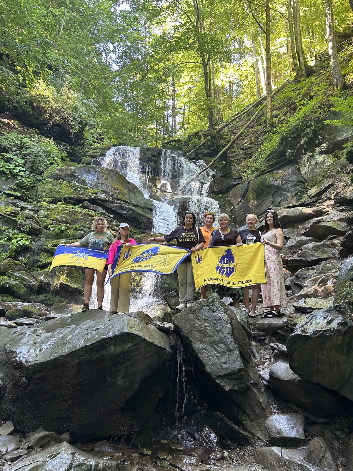 Спільнота My Grieving з прапорами захисників біля водоспаду